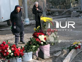 Elderly women stand in front of a floral tribute to the victims of the Russian missile attack that occurs in the Novokodatskyi district in t...