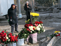 Elderly women stand in front of a floral tribute to the victims of the Russian missile attack that occurs in the Novokodatskyi district in t...