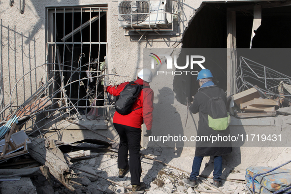 Experts examine the ruins of a residential building after the Russian missile attack in the Novokodatskyi district in Dnipro, Ukraine, on Oc...