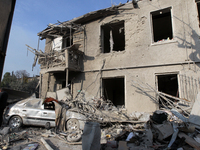 A crushed car is outside a residential building destroyed by the Russian missile attack in the Novokodatskyi district in Dnipro, Ukraine, on...