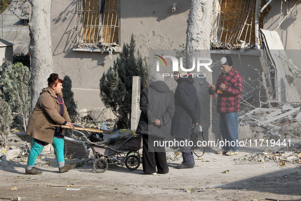 People stand outside a residential building after the Russian missile attack in the Novokodatskyi district in Dnipro, Ukraine, on October 25...