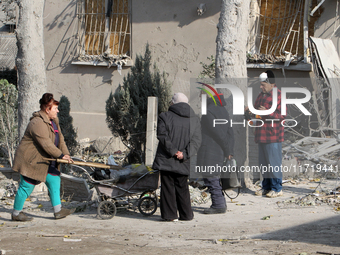 People stand outside a residential building after the Russian missile attack in the Novokodatskyi district in Dnipro, Ukraine, on October 25...