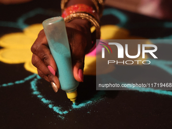 A woman creates a decorative rangoli design in preparation for the festival of Diwali in Toronto, Ontario, Canada, on October 24, 2024. Rang...