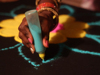 A woman creates a decorative rangoli design in preparation for the festival of Diwali in Toronto, Ontario, Canada, on October 24, 2024. Rang...