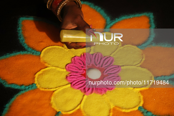 A woman creates a decorative rangoli design in preparation for the festival of Diwali in Toronto, Ontario, Canada, on October 24, 2024. Rang...