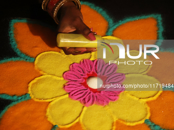 A woman creates a decorative rangoli design in preparation for the festival of Diwali in Toronto, Ontario, Canada, on October 24, 2024. Rang...