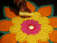 A woman creates a decorative rangoli design in preparation for the festival of Diwali in Toronto, Ontario, Canada, on October 24, 2024. Rang...