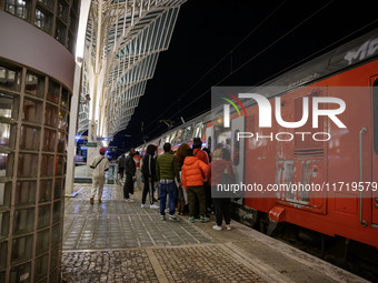 People board a train on one of the platforms at Oriente railway station in Lisbon, Portugal, on October 28, 2024. Due to a growing shortfall...