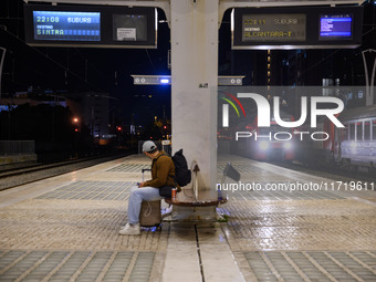 A person with suitcases sits waiting for the arrival of a train on one of the platforms of Oriente railway station in Lisbon, Portugal, on O...