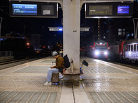 A person with suitcases sits waiting for the arrival of a train on one of the platforms of Oriente railway station in Lisbon, Portugal, on O...