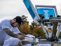 A volunteer prints t-shirts on site at a rally where Vice President Kamala Harris will deliver what her campaign has billed as a “closing ar...