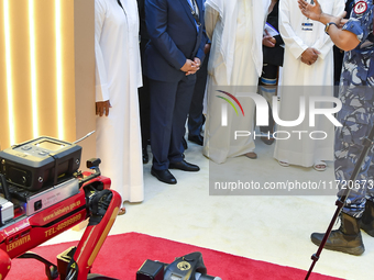 Sheikh Khalifa bin Hamad bin Khalifa Al Thani, Qatar Minister of Interior, looks at smart communication systems after the opening ceremony o...