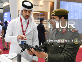 A visiting Kuwait defense official inspects a weapon after the opening ceremony of the 15th edition of the Milipol Qatar 2024 Exhibition and...