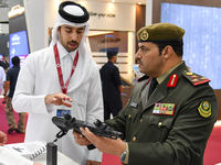 A visiting Kuwait defense official inspects a weapon after the opening ceremony of the 15th edition of the Milipol Qatar 2024 Exhibition and...