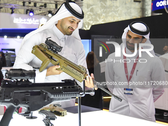 A Qatari visitor looks at the automatic gun during the 15th edition of the Milipol Qatar 2024 Exhibition and Conference in Doha, Qatar, on O...