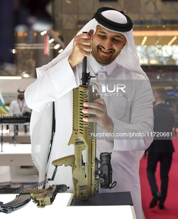 A Qatari visitor looks at the automatic gun during the 15th edition of the Milipol Qatar 2024 Exhibition and Conference in Doha, Qatar, on O...