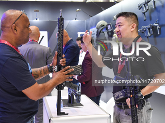 A visitor inspects an assault rifle on display at the 15th edition of the Milipol Qatar 2024 Exhibition and Conference in Doha, Qatar, on Oc...