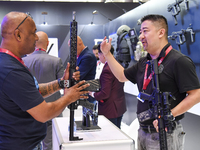 A visitor inspects an assault rifle on display at the 15th edition of the Milipol Qatar 2024 Exhibition and Conference in Doha, Qatar, on Oc...