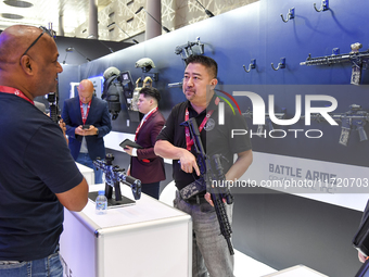 A visitor inspects an assault rifle on display at the 15th edition of the Milipol Qatar 2024 Exhibition and Conference in Doha, Qatar, on Oc...