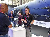 A visitor inspects an assault rifle on display at the 15th edition of the Milipol Qatar 2024 Exhibition and Conference in Doha, Qatar, on Oc...