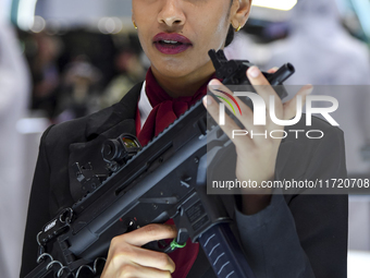 A visitor looks through the sights of a shotgun being demonstrated at the 15th edition of the Milipol Qatar 2024 Exhibition and Conference i...