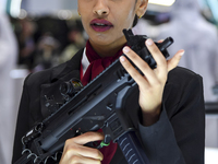 A visitor looks through the sights of a shotgun being demonstrated at the 15th edition of the Milipol Qatar 2024 Exhibition and Conference i...