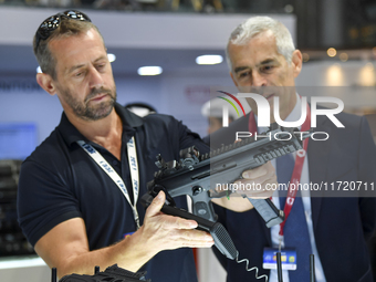 A visitor inspects an assault rifle on display at the 15th edition of the Milipol Qatar 2024 Exhibition and Conference in Doha, Qatar, on Oc...