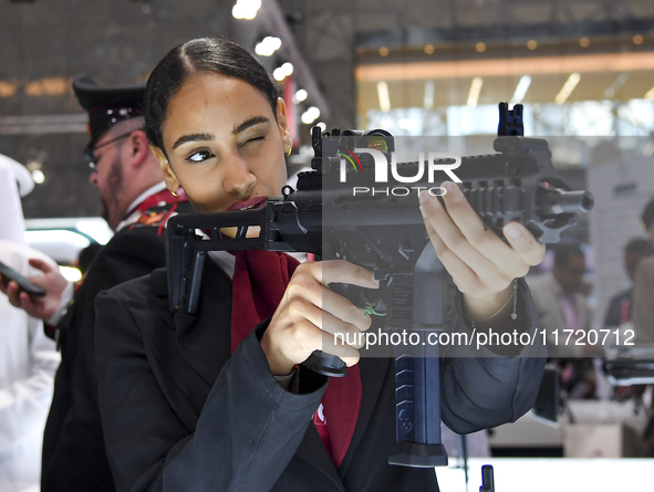 A visitor aims with her assault rifle during the 15th edition of the Milipol Qatar 2024 Exhibition and Conference in Doha, Qatar, on October...