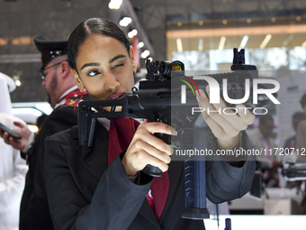 A visitor aims with her assault rifle during the 15th edition of the Milipol Qatar 2024 Exhibition and Conference in Doha, Qatar, on October...