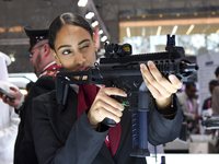 A visitor aims with her assault rifle during the 15th edition of the Milipol Qatar 2024 Exhibition and Conference in Doha, Qatar, on October...