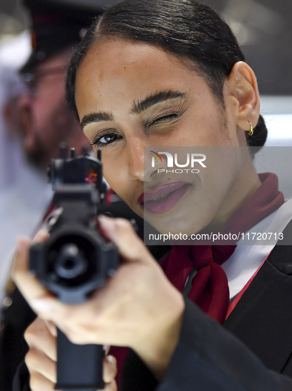 A visitor aims with her assault rifle during the 15th edition of the Milipol Qatar 2024 Exhibition and Conference in Doha, Qatar, on October...