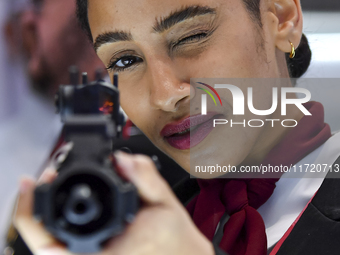 A visitor aims with her assault rifle during the 15th edition of the Milipol Qatar 2024 Exhibition and Conference in Doha, Qatar, on October...