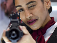 A visitor aims with her assault rifle during the 15th edition of the Milipol Qatar 2024 Exhibition and Conference in Doha, Qatar, on October...