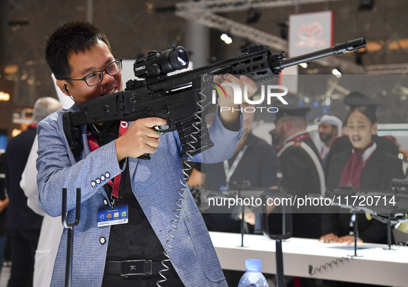 A visitor inspects an assault rifle on display at the 15th edition of the Milipol Qatar 2024 Exhibition and Conference in Doha, Qatar, on Oc...