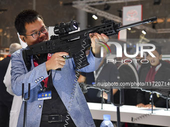 A visitor inspects an assault rifle on display at the 15th edition of the Milipol Qatar 2024 Exhibition and Conference in Doha, Qatar, on Oc...