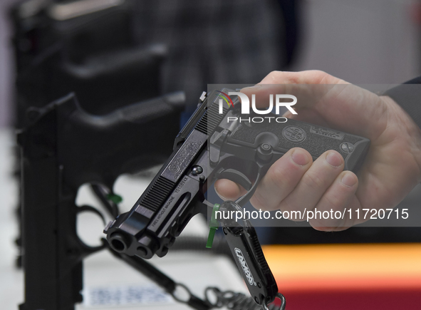 A visitor inspects an assault rifle on display at the 15th edition of the Milipol Qatar 2024 Exhibition and Conference in Doha, Qatar, on Oc...