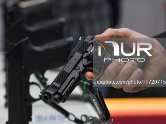 A visitor inspects an assault rifle on display at the 15th edition of the Milipol Qatar 2024 Exhibition and Conference in Doha, Qatar, on Oc...