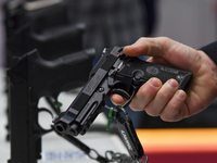 A visitor inspects an assault rifle on display at the 15th edition of the Milipol Qatar 2024 Exhibition and Conference in Doha, Qatar, on Oc...