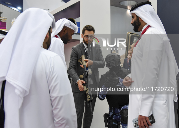 Visitors inspect a weapon during their visit to the 15th edition of the Milipol Qatar 2024 Exhibition and Conference in Doha, Qatar, on Octo...