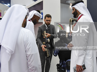 Visitors inspect a weapon during their visit to the 15th edition of the Milipol Qatar 2024 Exhibition and Conference in Doha, Qatar, on Octo...