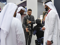 Visitors inspect a weapon during their visit to the 15th edition of the Milipol Qatar 2024 Exhibition and Conference in Doha, Qatar, on Octo...