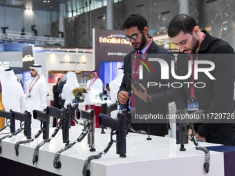 Visitors inspect pistols on display at the 15th edition of the Milipol Qatar 2024 Exhibition and Conference in Doha, Qatar, on October 29, 2...