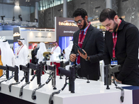 Visitors inspect pistols on display at the 15th edition of the Milipol Qatar 2024 Exhibition and Conference in Doha, Qatar, on October 29, 2...