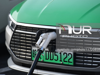 Electric vehicles are charged at a street charging station in Fuyang, China, on October 30, 2024. (