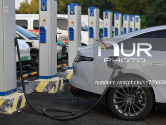 Electric vehicles are charged at a street charging station in Fuyang, China, on October 30, 2024. (