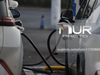 Electric vehicles are charged at a street charging station in Fuyang, China, on October 30, 2024. (