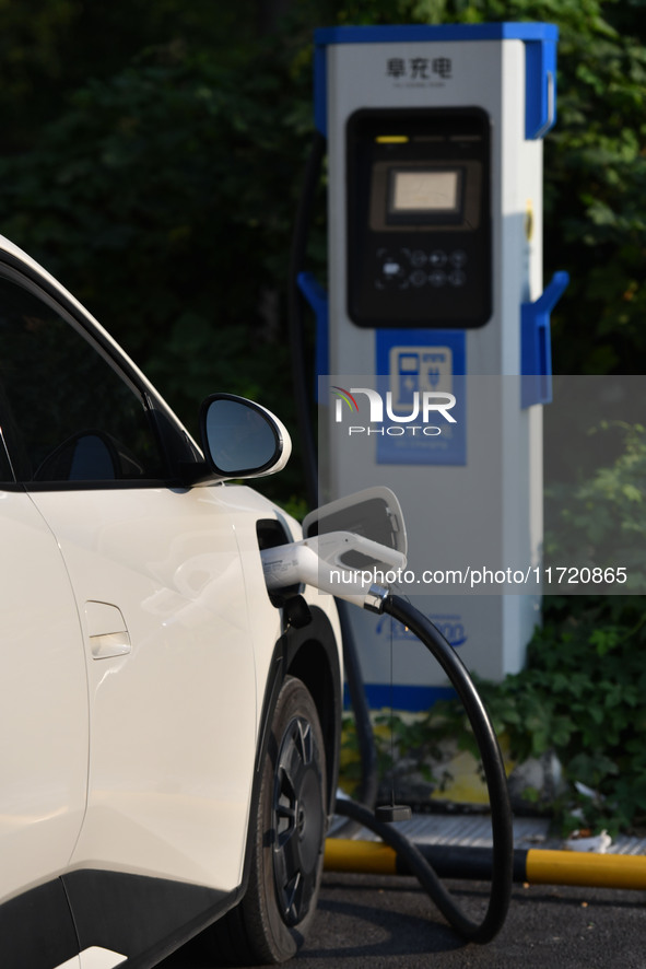 Electric vehicles are charged at a street charging station in Fuyang, China, on October 30, 2024. 