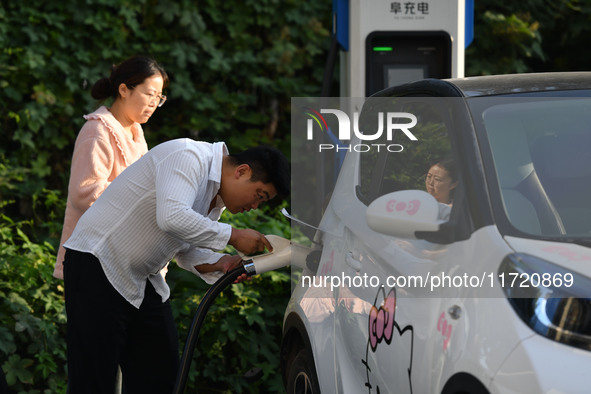 Electric vehicles are charged at a street charging station in Fuyang, China, on October 30, 2024. 