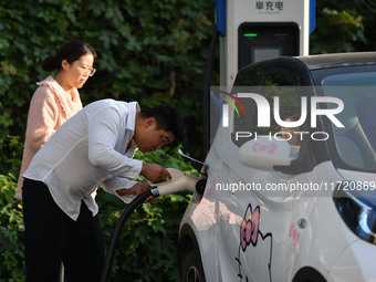 Electric vehicles are charged at a street charging station in Fuyang, China, on October 30, 2024. (