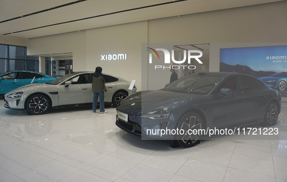 Customers buy a Xiaomi SU7 new energy vehicle at a Xiaomi Auto store in Hangzhou, China, on October 30, 2024. 